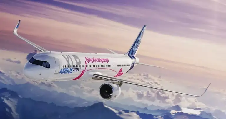 Avión Airbus A321XLR de prueba volando sobre montañas nevadas al atardecer.