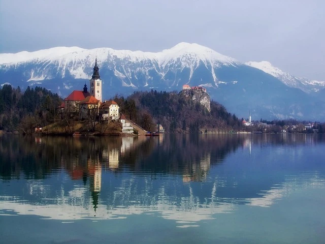 Lago Bled en Eslovenia: un destino de cuento entre montañas y naturaleza Iglesia en la isla del Lago Bled con los Alpes Julianos nevados al fondo