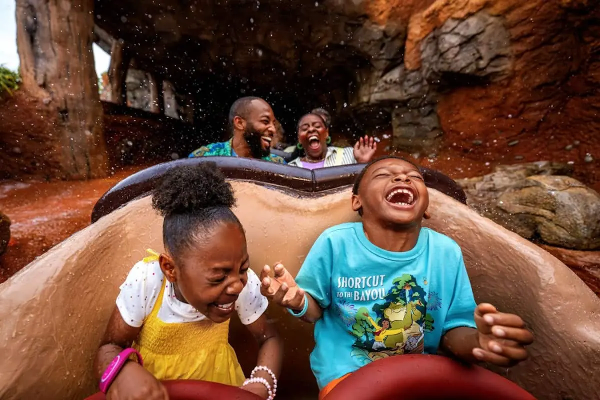 montaña rusa de disney, van 2 niños adelante en un carrito y lospadres atras