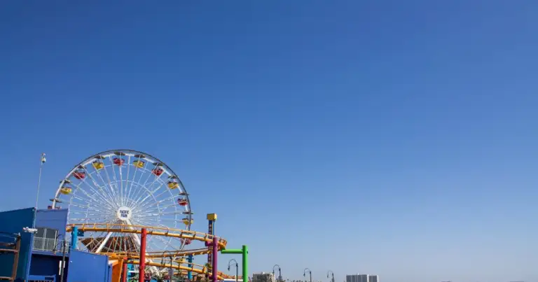 Rueda de la fortuna en el muelle de Santa Mónica, California, con vista al mar y cielo despejado.