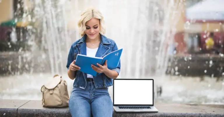 una mujer leyendo con la computadora al lado. viajar y estudiar
