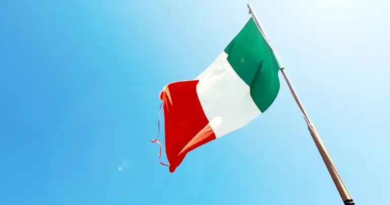 Bandera de Italia ondeando sobre un cielo azul claro