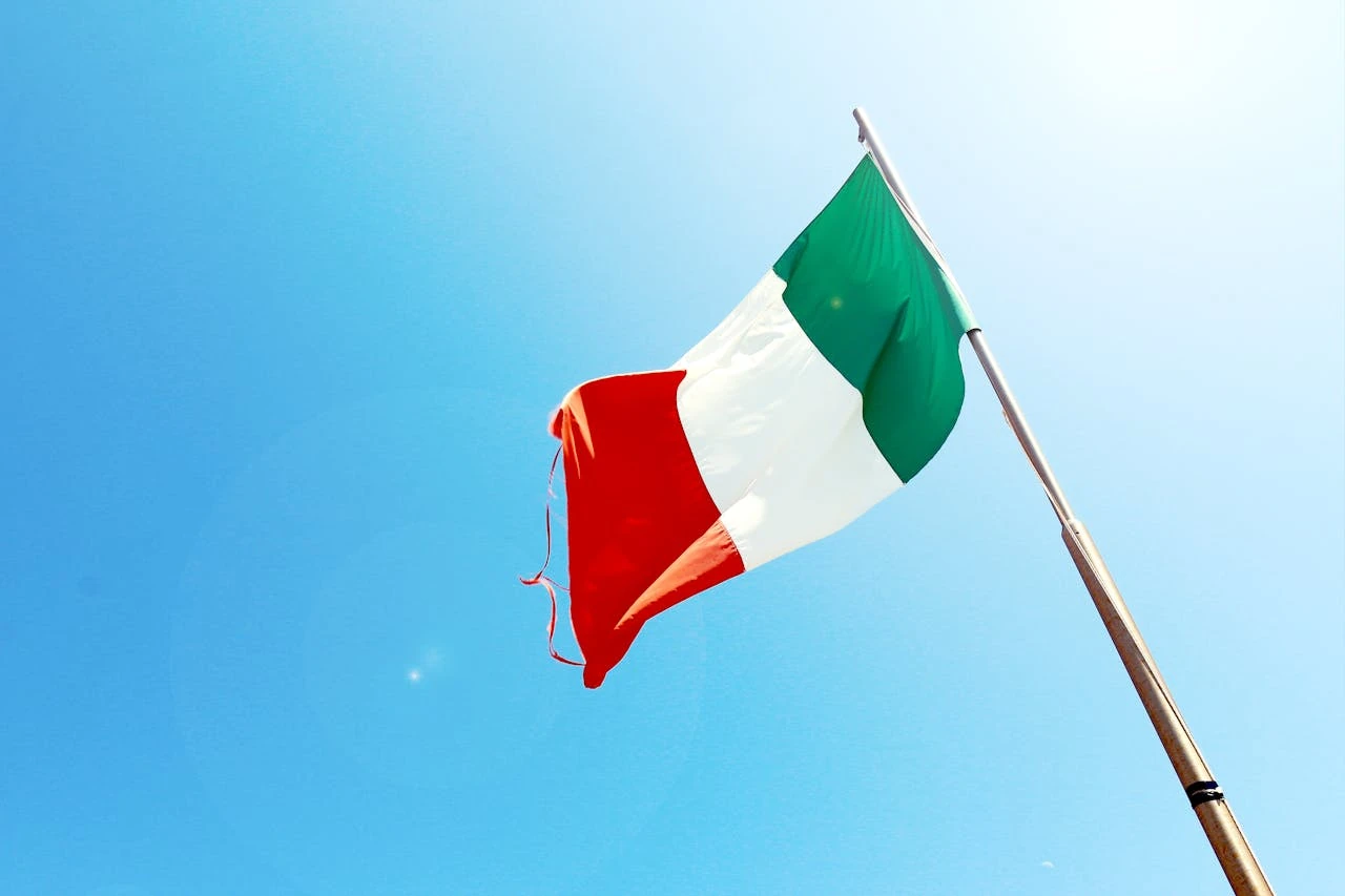 Bandera de Italia ondeando sobre un cielo azul claro