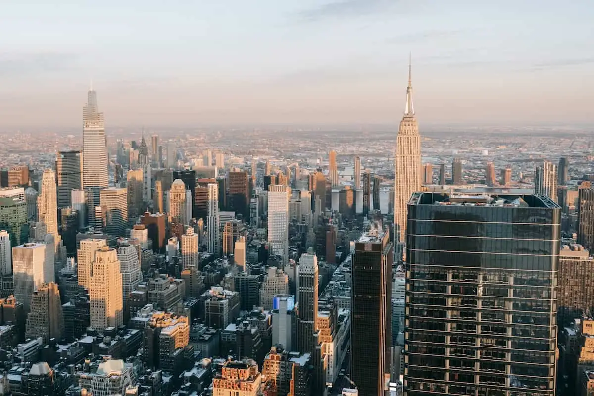Vista aérea de los rascacielos de Manhattan al atardecer, con el Empire State destacado.