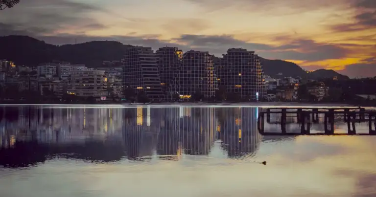Atardecer en Vlorë, Albania, con edificios modernos reflejados en el mar.