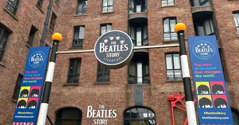 Entrada principal de The Beatles Story en Liverpool, con carteles promocionales del museo.
