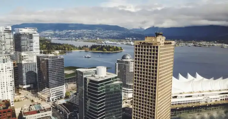 Vista aérea del centro de Vancouver con Canada Place, rascacielos y el puerto con montañas de fondo