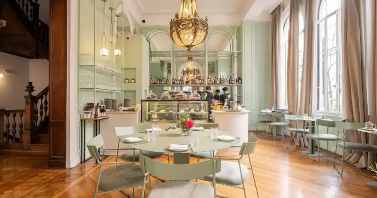 Salón de Amayta en Recoleta con barra, lámpara de araña y mesas elegantes.