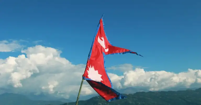 Bandera de Nepal ondeando con el Himalaya de fondo