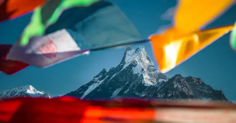Montaña nevada del Himalaya con banderas de oración tibetanas al frente