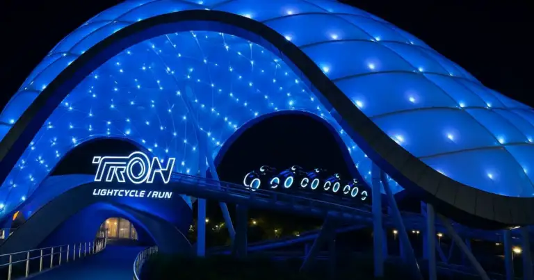 La cúpula iluminada de TRON Lightcycle Run brilla en la noche de Magic Kingdom, ofreciendo una experiencia única para los fanáticos de la velocidad y la tecnología.
