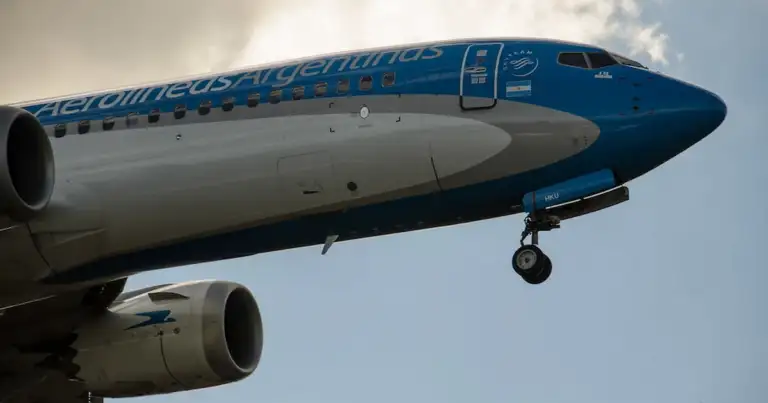 Avión de Aerolíneas Argentinas despegando, con detalle del fuselaje y motor.