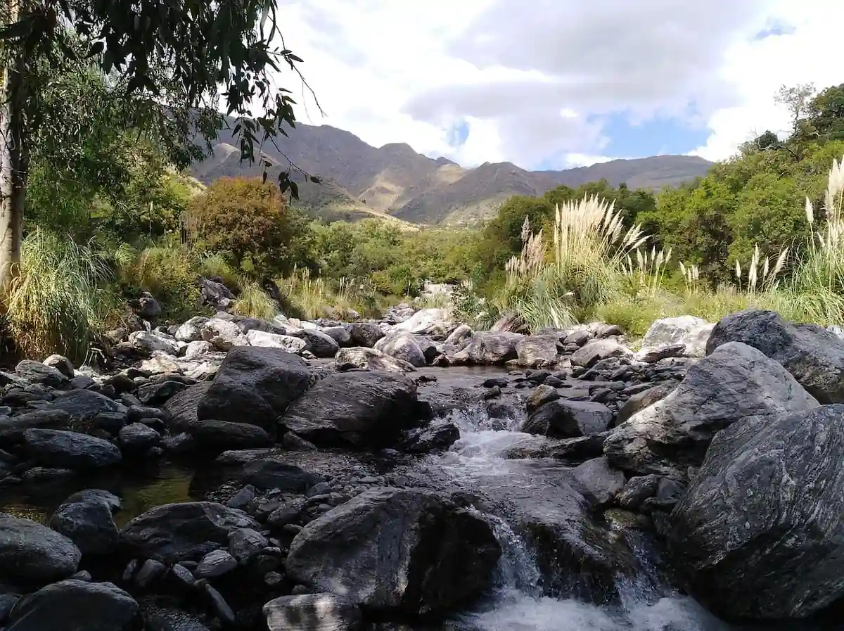 Arroyo serrano en Merlo, San Luis Arroyo de montaña en Merlo, San Luis, con rocas, vegetación nativa y sierras al fondo
