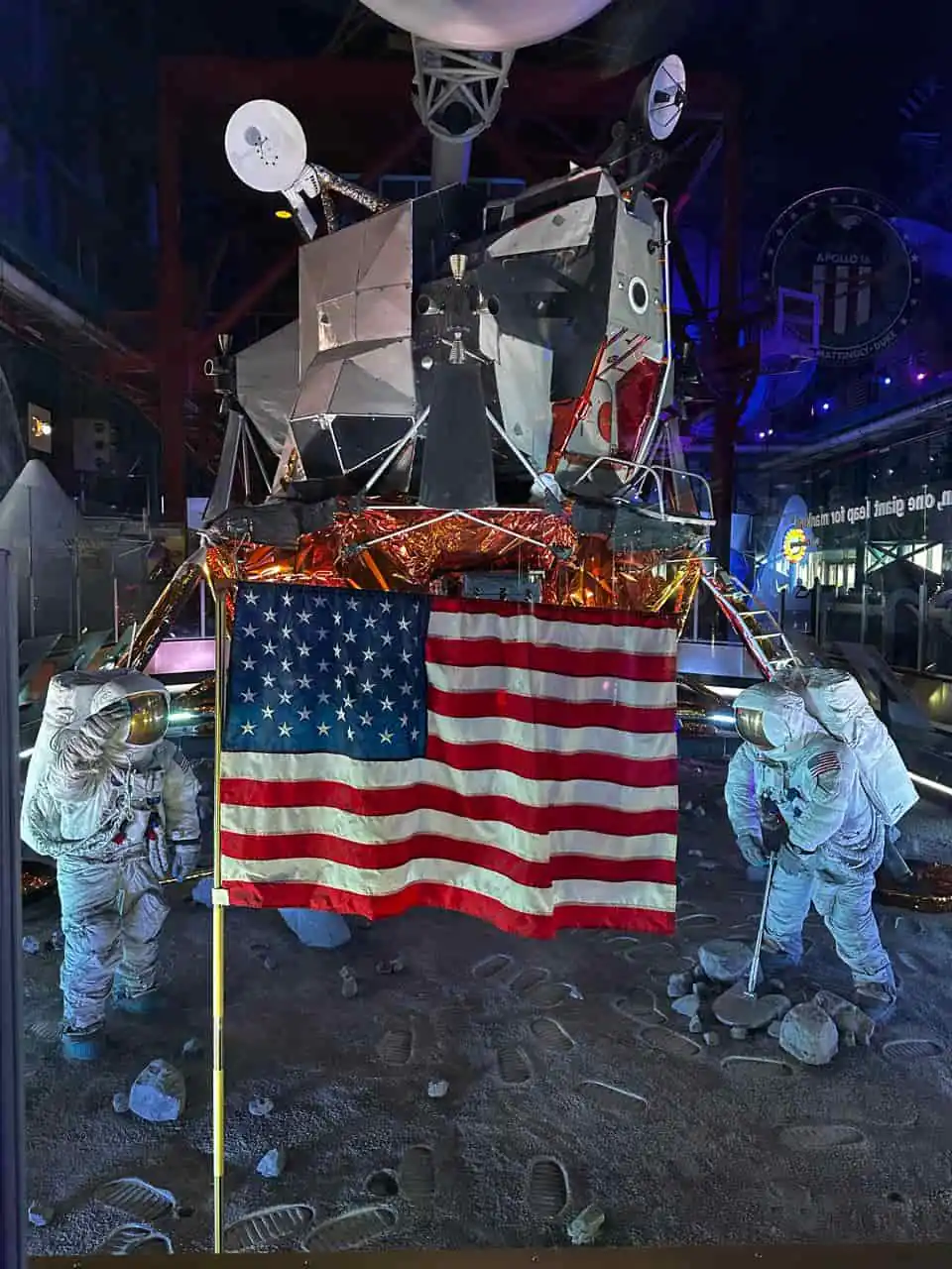 Módulo lunar del programa Apollo en el Kennedy Space Center con astronautas y bandera de Estados Unidos
