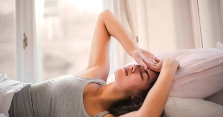 Persona descansando en la cama durante la mañana en vacaciones enfocadas en dormir mejor