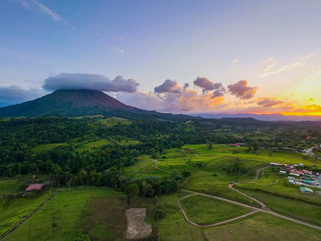 Volcán y paisaje verde de Costa Rica al atardecer, ideal para viajar en temporada seca o de naturaleza.