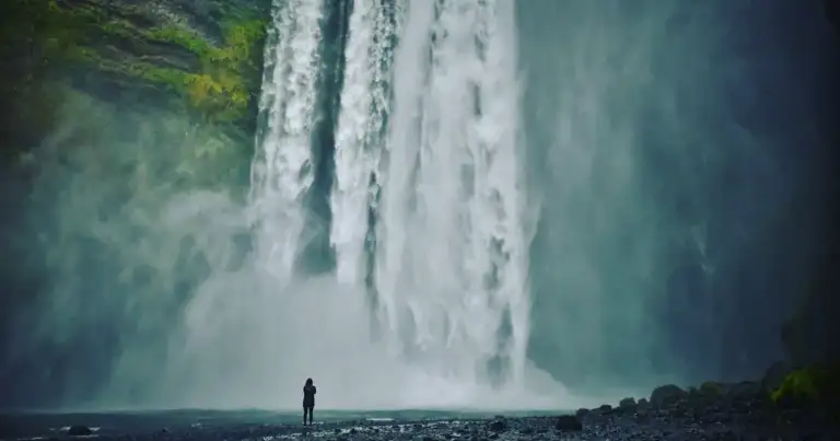 Cascada Skogafoss en Islandia con persona frente al salto de agua