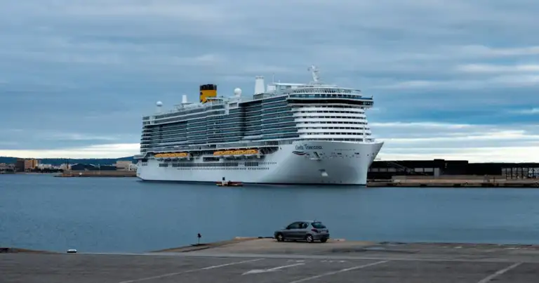 Crucero atracado en un puerto europeo bajo un cielo nublado, una imagen que representa las medidas de Barcelona para limitar el impacto del turismo de cruceros y cobrar una nueva tasa a visitantes.