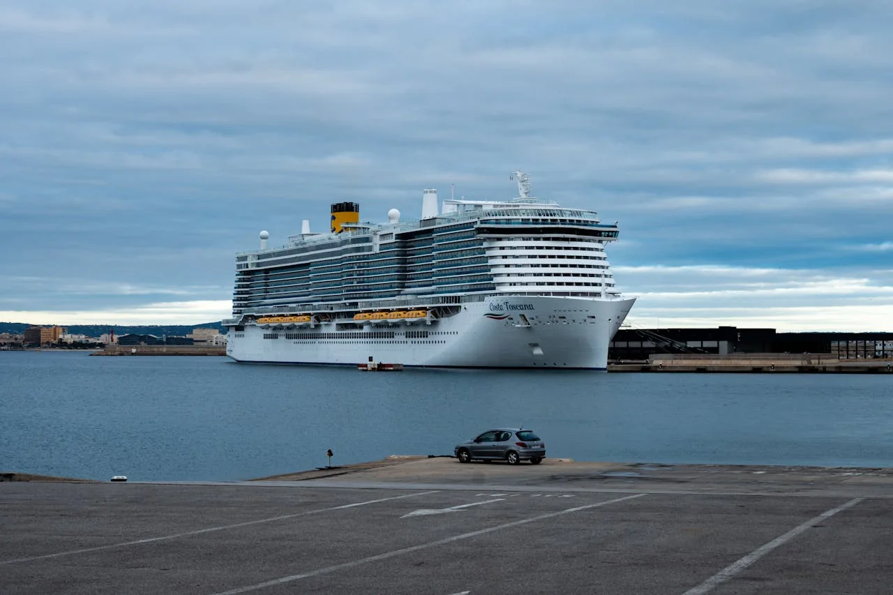 Crucero atracado en un puerto europeo bajo un cielo nublado, una imagen que representa las medidas de Barcelona para limitar el impacto del turismo de cruceros y cobrar una nueva tasa a visitantes.