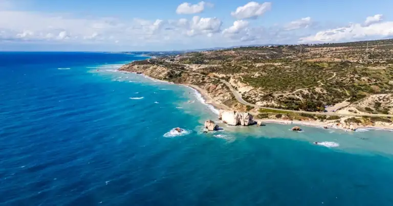 Vista aérea de la costa de Chipre sobre el mar Mediterráneo, con acantilados, playas y aguas turquesas.