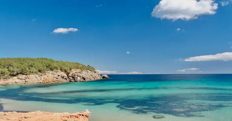 Cala de Ibiza con aguas turquesas y costa rocosa, una imagen que ayuda a ubicar la isla en el mar Mediterráneo dentro de las Islas Baleares.