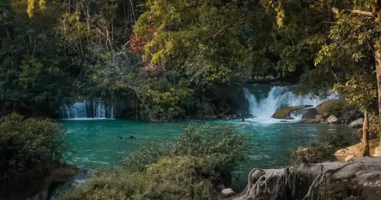 Río de agua turquesa rodeado de vegetación y pequeñas cascadas, una imagen que representa las escapadas desde Monterrey para disfrutar naturaleza, descanso y paisajes al aire libre.
