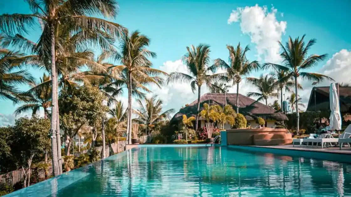 Resort de lujo con piscina infinita, palmeras y vista tropical, una imagen que representa los hoteles más caros del mundo en 2026 y las experiencias exclusivas de alto nivel.