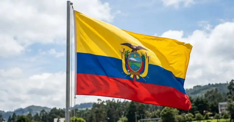Bandera de Ecuador ondeando frente a un paisaje verde, imagen relacionada con una guía sobre dónde queda Ecuador y cómo llegar.