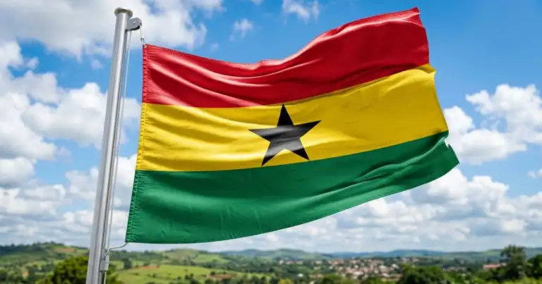 Bandera de Ghana ondeando sobre un paisaje verde, imagen relacionada con una guía sobre dónde queda Ghana y qué saber antes de viajar.