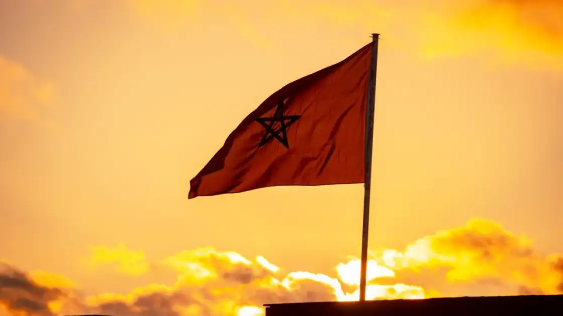 Bandera de Marruecos al atardecer, imagen relacionada con una guía sobre dónde queda Marruecos y qué ver en el país.
