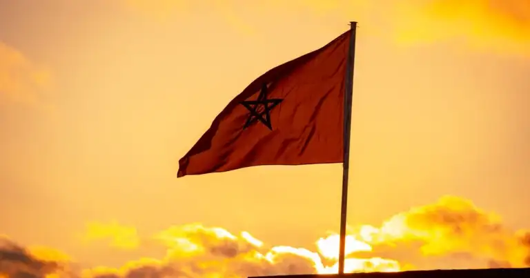 Bandera de Marruecos al atardecer, imagen relacionada con una guía sobre dónde queda Marruecos y qué ver en el país.