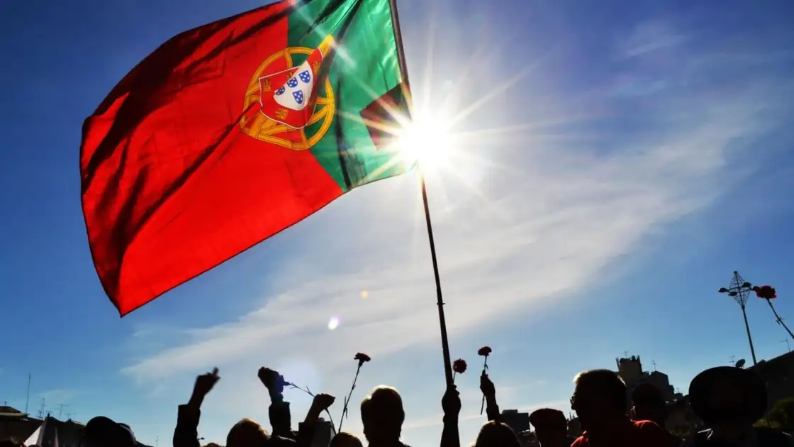 Bandera de Portugal ondeando al sol, imagen relacionada con una guía sobre dónde queda Portugal y qué saber antes de viajar.