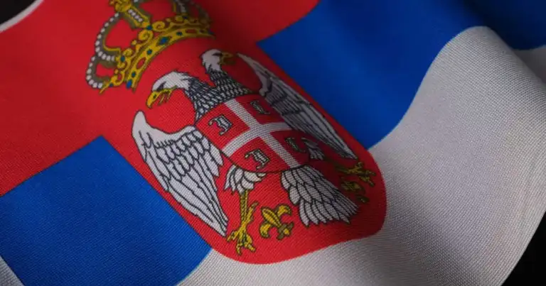 Bandera de Serbia con su escudo nacional, imagen relacionada con una guía sobre dónde queda Serbia en Europa.