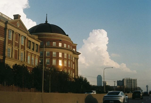 Vista urbana de Dallas con edificios históricos, autopista y skyline al fondo, imagen para una guía sobre qué hacer en la ciudad.