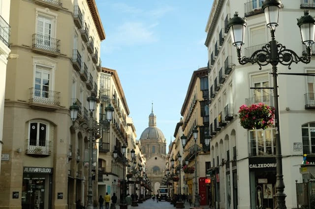 Calle del centro histórico de Zaragoza con vista a la Basílica del Pilar, uno de los lugares clave durante las Fiestas del Pilar.