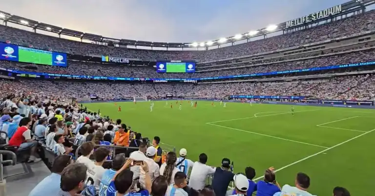 Interior del MetLife Stadium durante un partido de fútbol con tribunas llenas, sede de la final del Mundial 2026 en Nueva York–Nueva Jersey.
