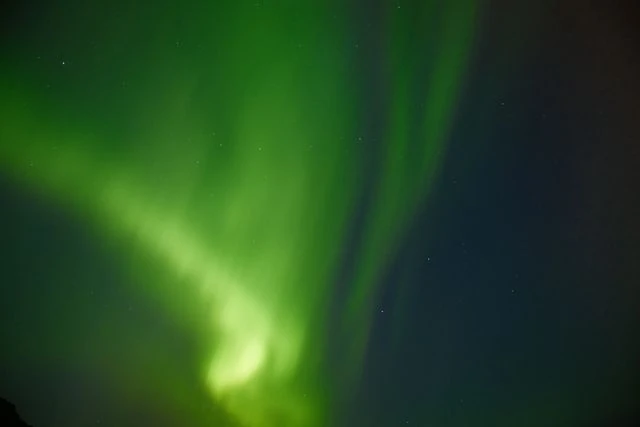 Aurora boreal de color verde iluminando el cielo nocturno de Islandia.