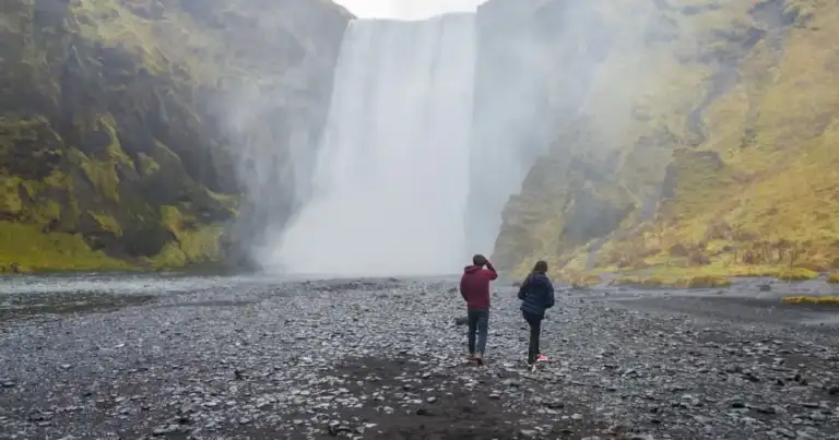 Viajeros frente a la cascada Skógafoss, una de las más famosas del sur de Islandia.