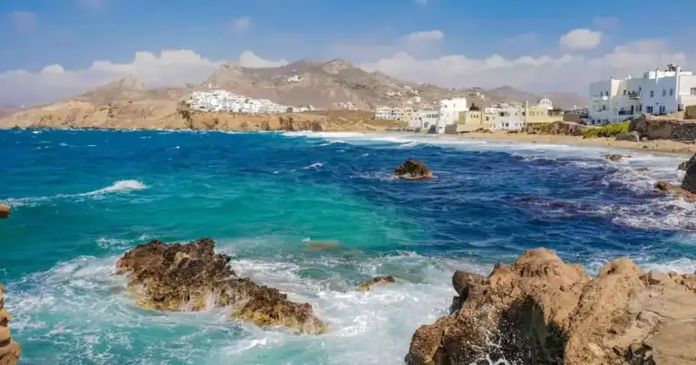 Costa rocosa de Mykonos, Grecia, con aguas turquesas y casas blancas junto al mar Egeo