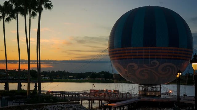 Globo Aerophile de Disney Springs al atardecer, junto al lago y las palmeras de Orlando.