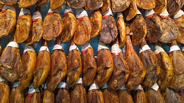 Jamones ibéricos curados colgados en una bodega de jamón en España