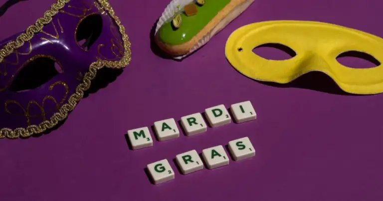 Máscaras de carnaval, letras con la frase Mardi Gras y un dulce decorado sobre un fondo morado.