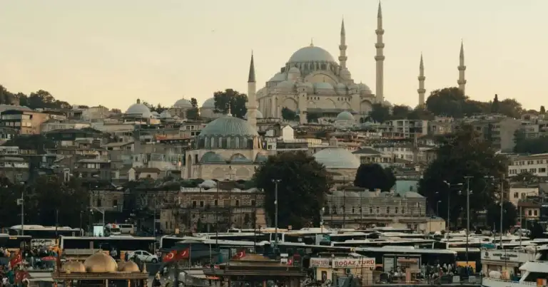 Vista de Estambul desde el agua con embarcaciones, la costa urbana y la mezquita de Süleymaniye dominando el horizonte.