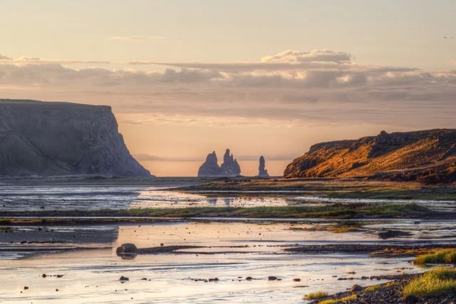 Formaciones rocosas de Reynisdrangar frente a la costa de Vík, en el sur de Islandia, durante el atardecer.