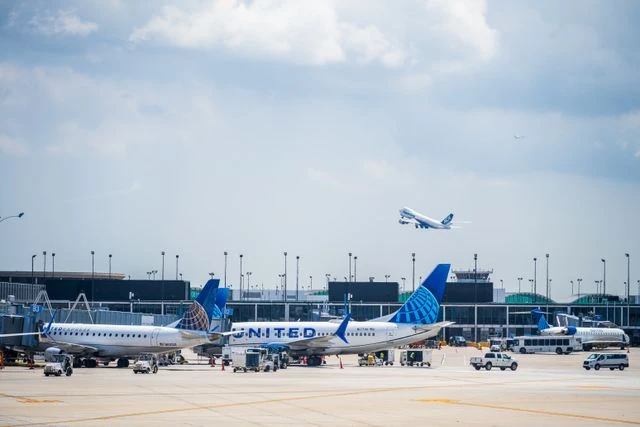 Aviones de United Airlines en una terminal de un aeropuerto de Estados Unidos mientras otra aeronave despega