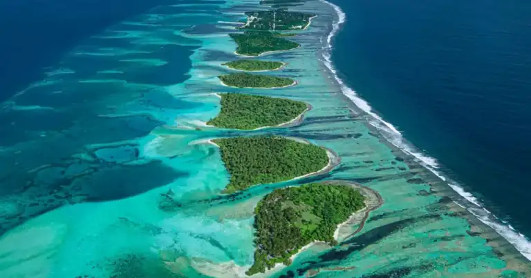 Vista aérea de una cadena de pequeñas islas tropicales rodeadas de arrecifes y aguas turquesas