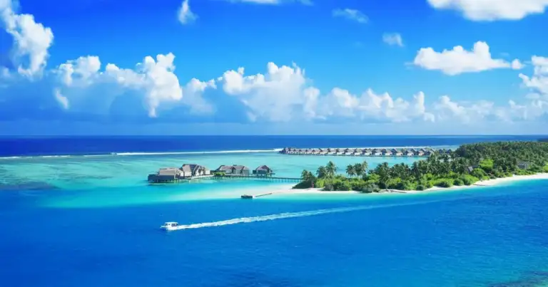Resort en Maldivas con villas sobre el agua, laguna turquesa y cielo despejado