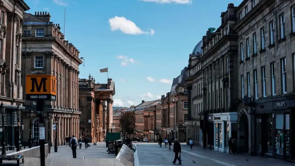 Grey Street en Newcastle upon Tyne, con edificios históricos, comercios y peatones en el centro de la ciudad