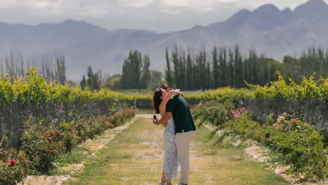 Pareja entre viñedos de Mendoza con montañas al fondo durante una visita a bodegas
