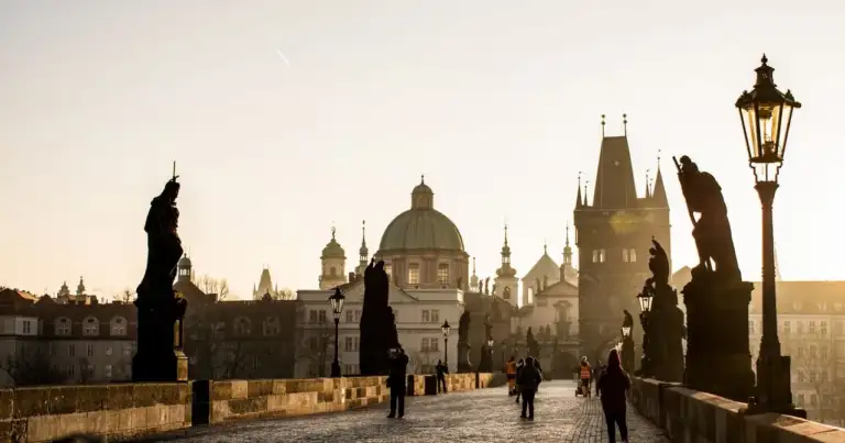 Puente de Carlos en Praga con sus estatuas y edificios históricos al amanecer